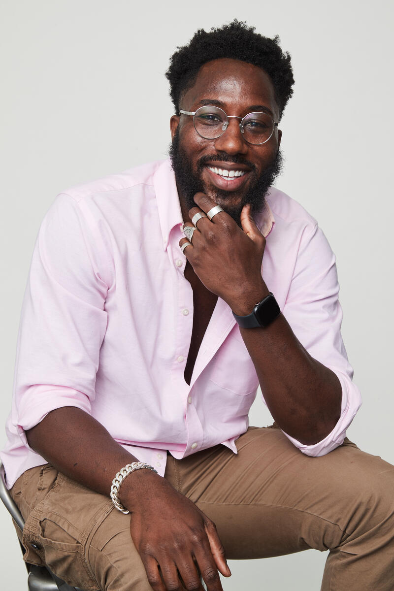 Headshot of Nseke Ngilbus wearing a light pink button down dress shirt.