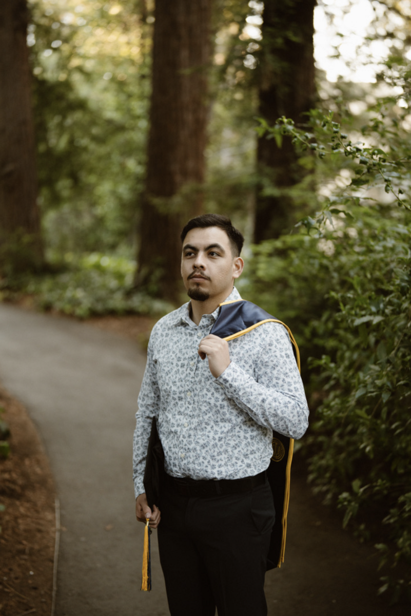 Headshot of Pedro Rodriguez looking off camera with his graduation stole draped off his shoulder.