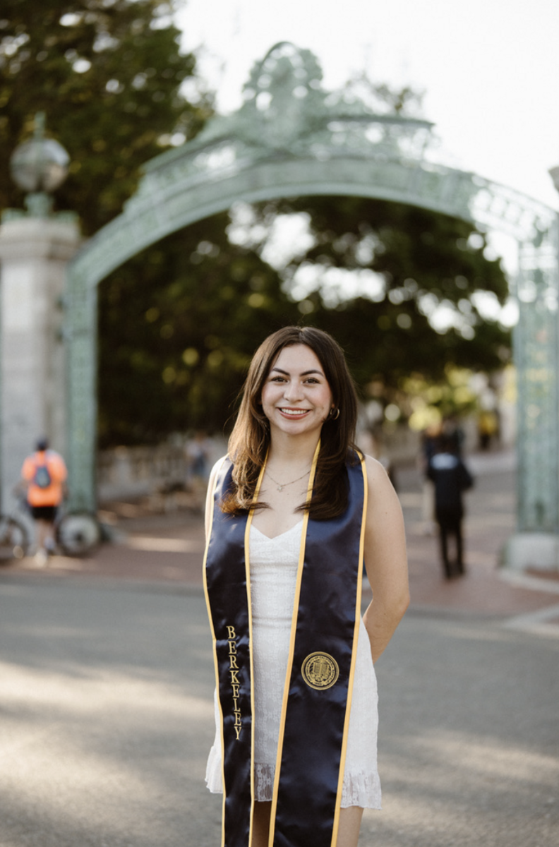 Olga Rodriguez posed in front of Sather Gate in a white dress and her graduation stole around her neck.